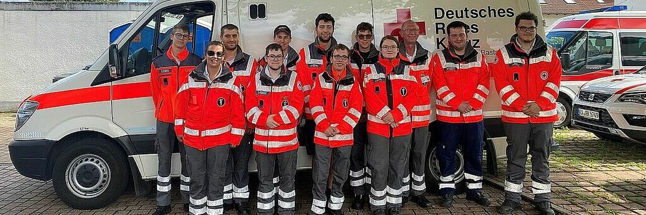 mehrere DRK-Helfer stehen einem Krankenwagen des Katastrophenschutz mehrere DRK-Helfer stehen einem Krankenwagen des Katastrophenschutz